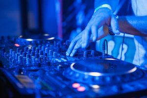 dj-playing-music-at-mixer-on-colorful-blurred-background.jpg